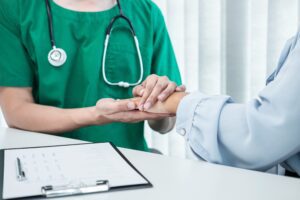 Hand of doctor touching patient reassuring for encouragement and empathy to support while medical examination on the hospital.